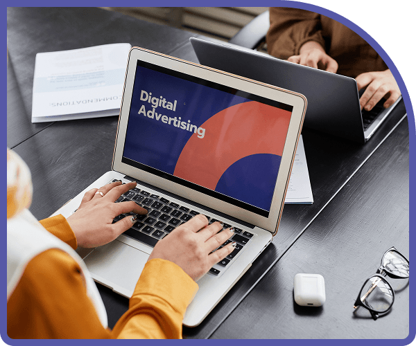 Person working on laptop with Digital Advertising screen